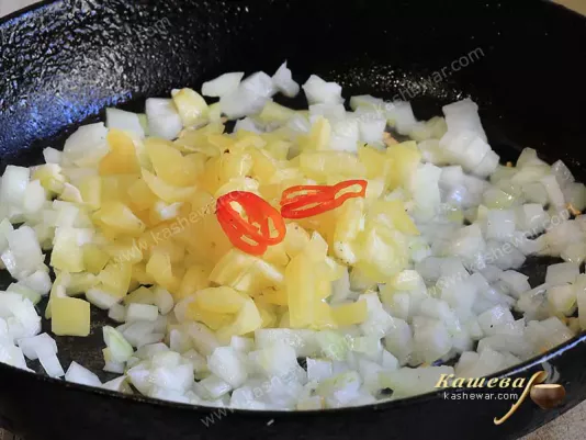 Onions and two kinds of peppers in a pan