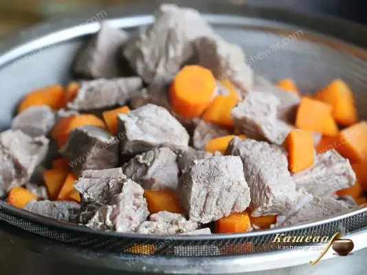 Beef and carrots in a sieve