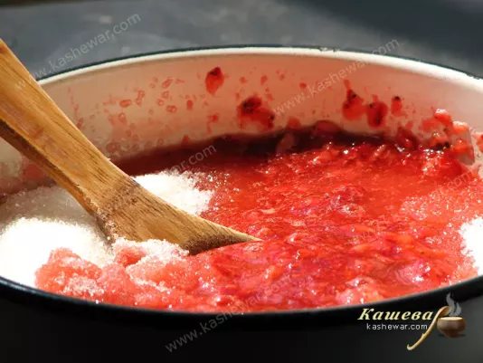 Mixing sugar and strawberries for jam