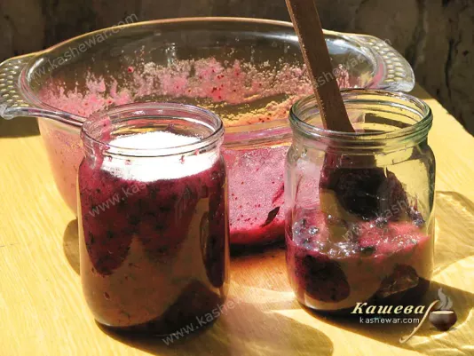Shifting black currant grated with sugar into jars