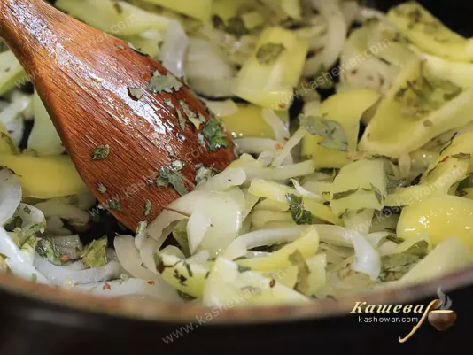 Солодкий перець, цибуля і листя каррі в сковороді.