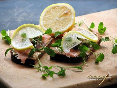 Выкладывание красной рыбы и других ингредиентов на бутерброды