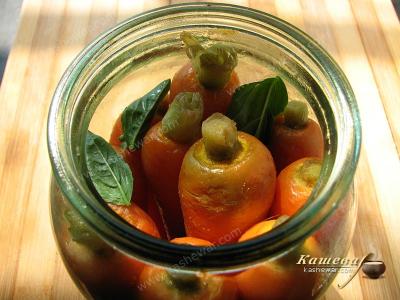 Placing pickled carrots in jars