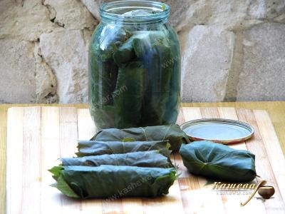 Stacking cucumbers in grape leaves in jars
