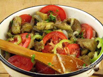 Смешивание ингредиентов салата из баклажанов и помидоров