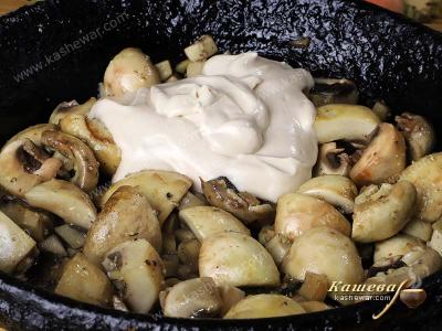 Champignons in a pan with sour cream