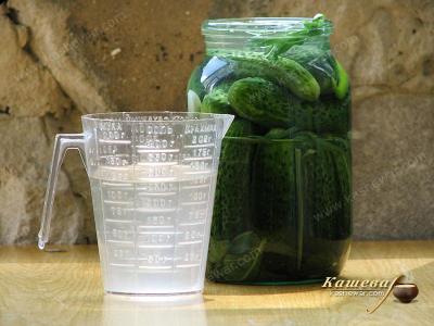 Putting cucumbers in jars and pouring with brine