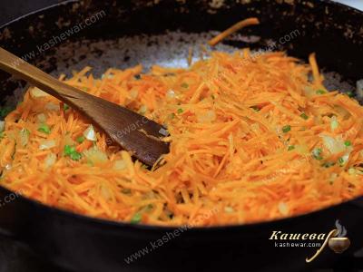Coarsely grated carrots with onions in a pan