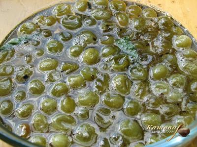 Cooking gooseberry jam with cherry leaves
