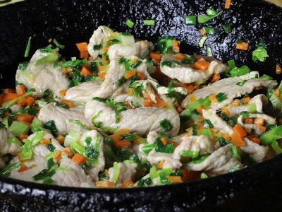 Pork with vegetables and herbs in a pan